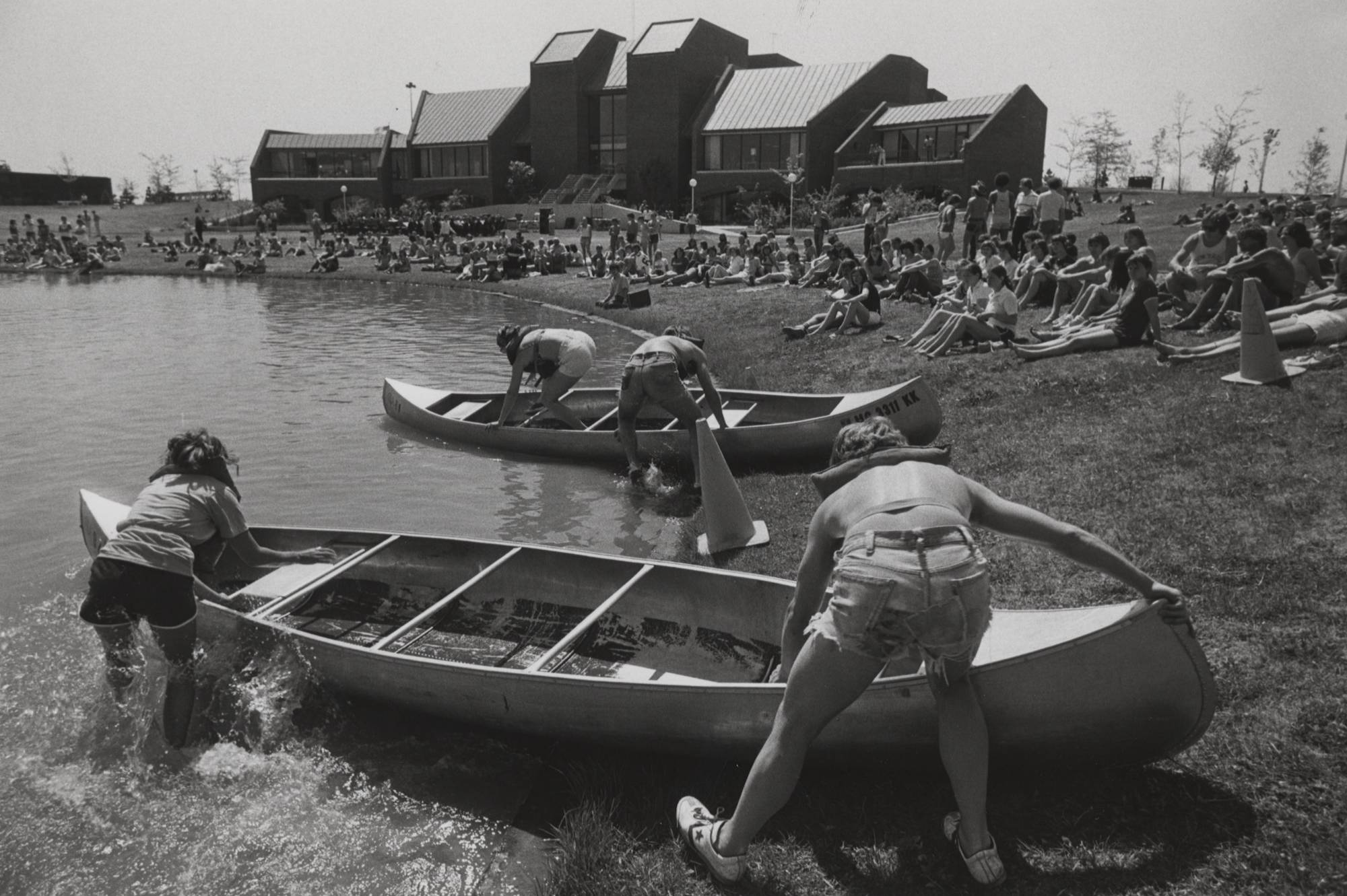 Students pushing their canoes into the pond.